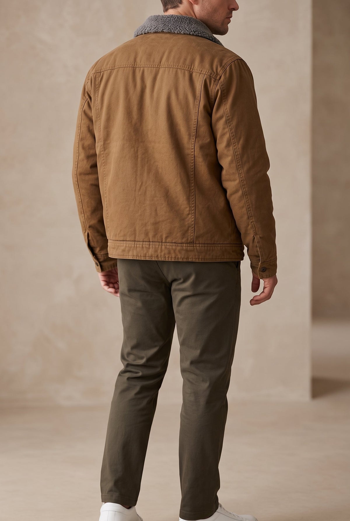 Back view on a model showing the tan jacket's seamed back panel and fleece collar 3