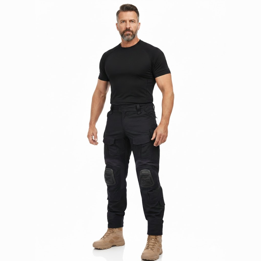 Full-length studio shot of a bearded model in a black t-shirt, the black cargo trousers and sand boots, facing the camera. 7