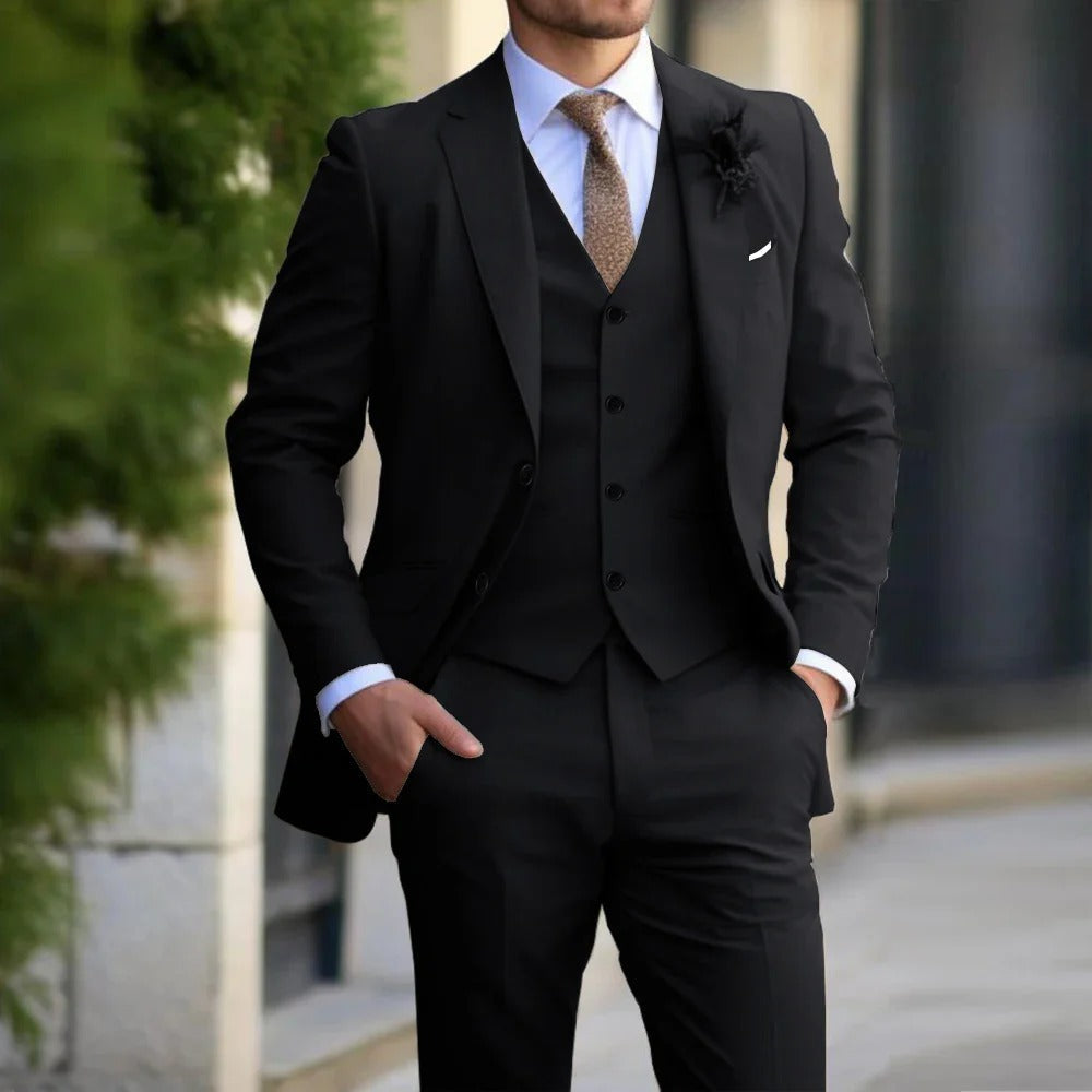 Model wearing the suit in black, with white shirt, brown tie and a dark lapel flower 3