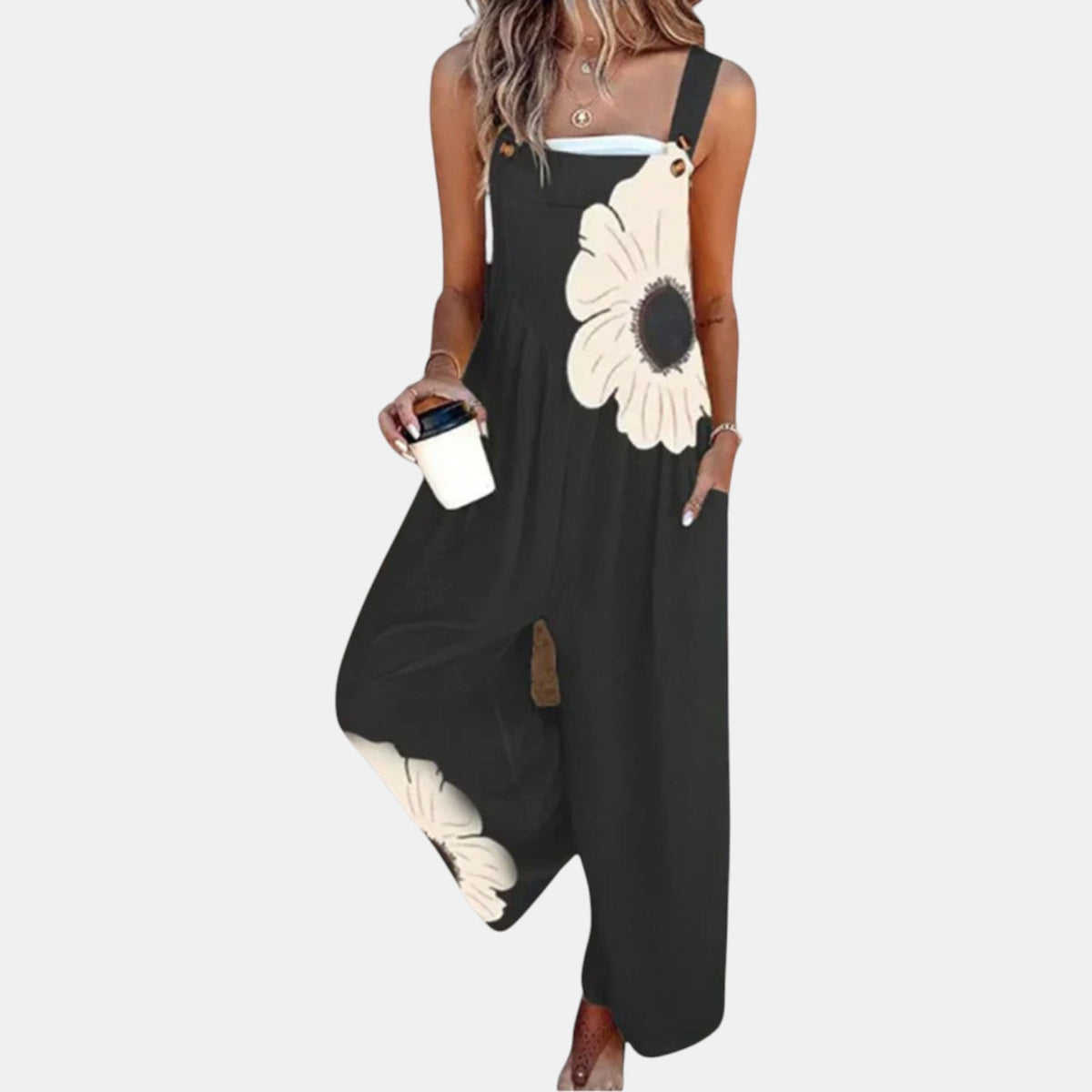 Model in black wide-leg dungarees with a large cream flower, holding a coffee cup 1