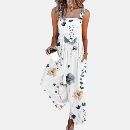 Model in white dungarees with a delicate blue and peach floral print, holding a coffee cup 4