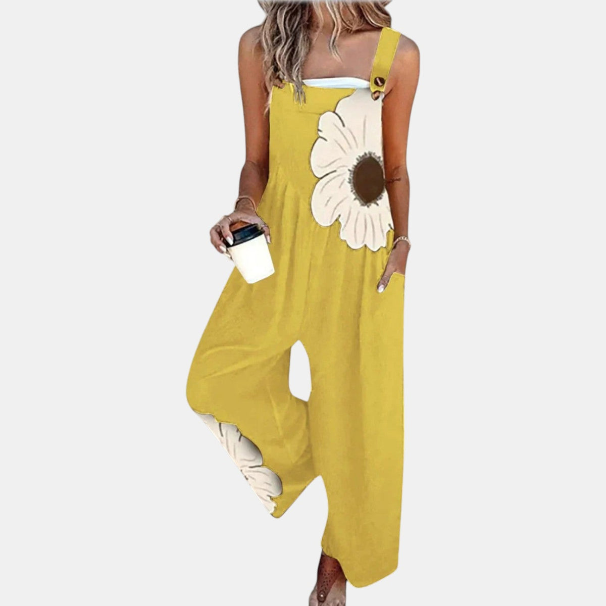 Model in yellow wide-leg dungarees with a large cream flower print, holding a coffee cup 9