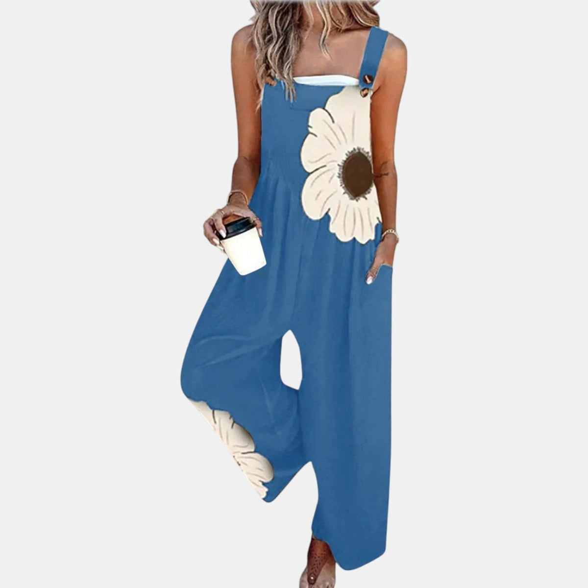 Model in blue wide-leg dungarees with a large cream flower print, holding a coffee cup 6