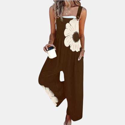 Model in dark brown wide-leg dungarees with a large cream flower print, holding a coffee cup 12