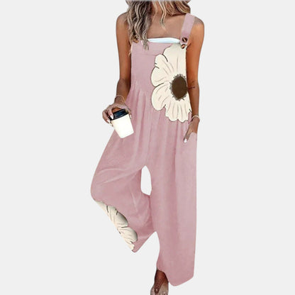Model in pink wide-leg dungarees with a large cream flower print, holding a coffee cup 7