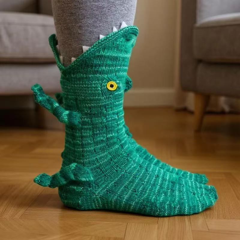 Green knitted crocodile sock with white teeth around the top and a yellow eye 15