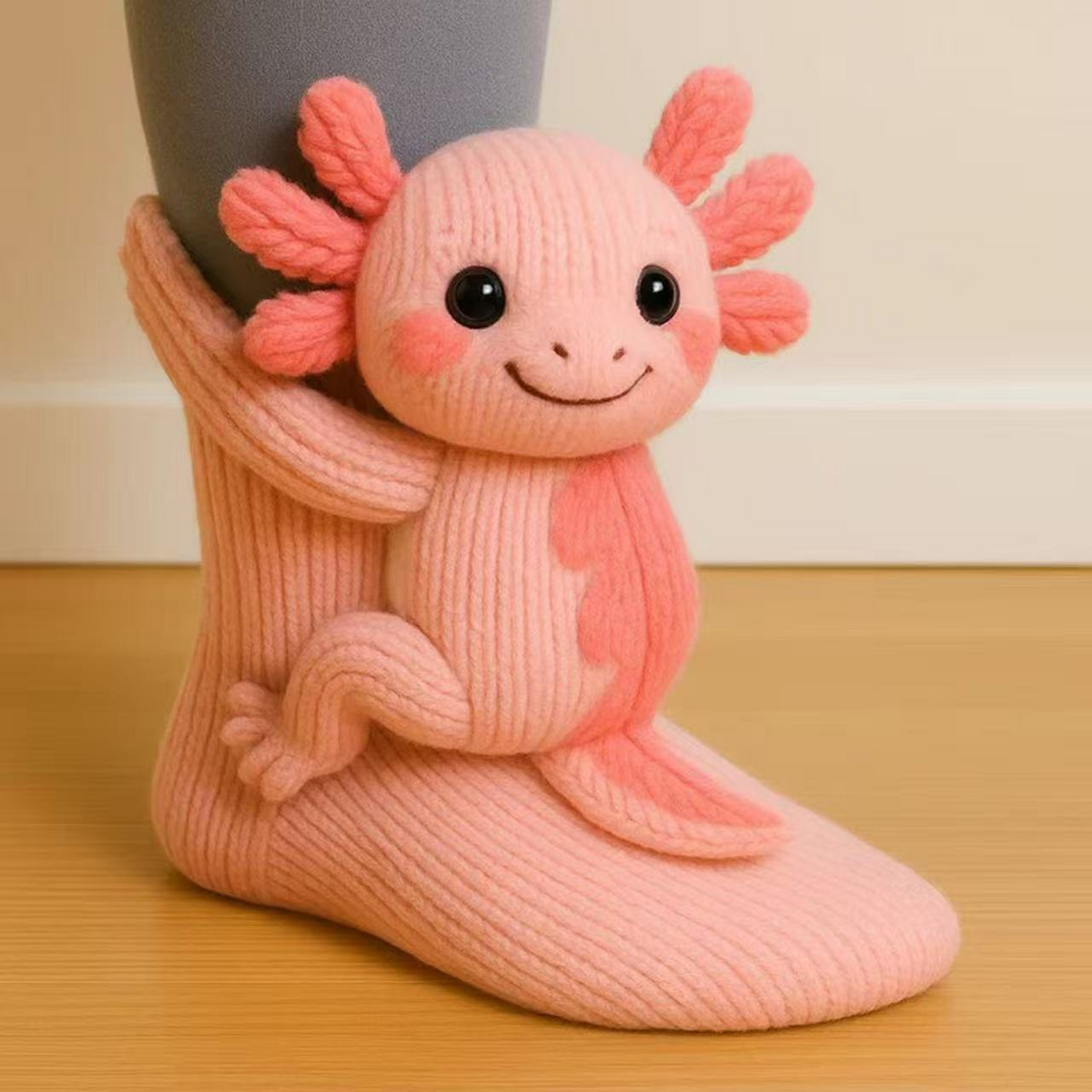 Coral-pink knitted sock with an axolotl figure with feathery gills, shown at an angle 16