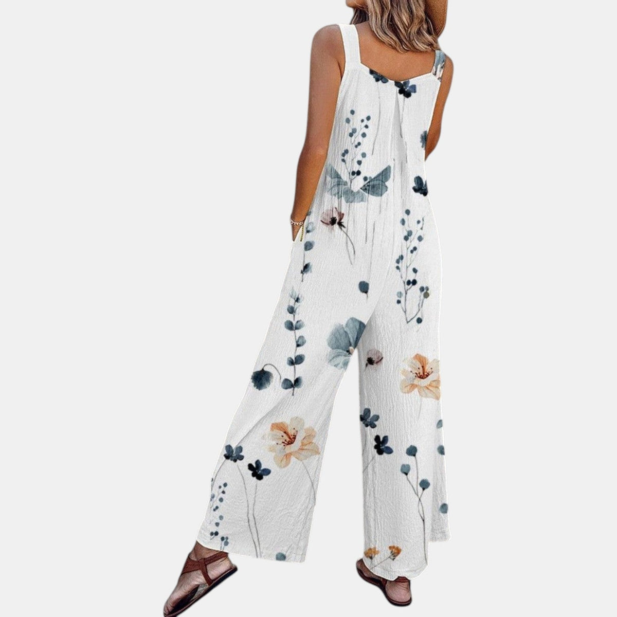 Back and side view of white floral dungarees with a wide, flowing leg and sandals 5