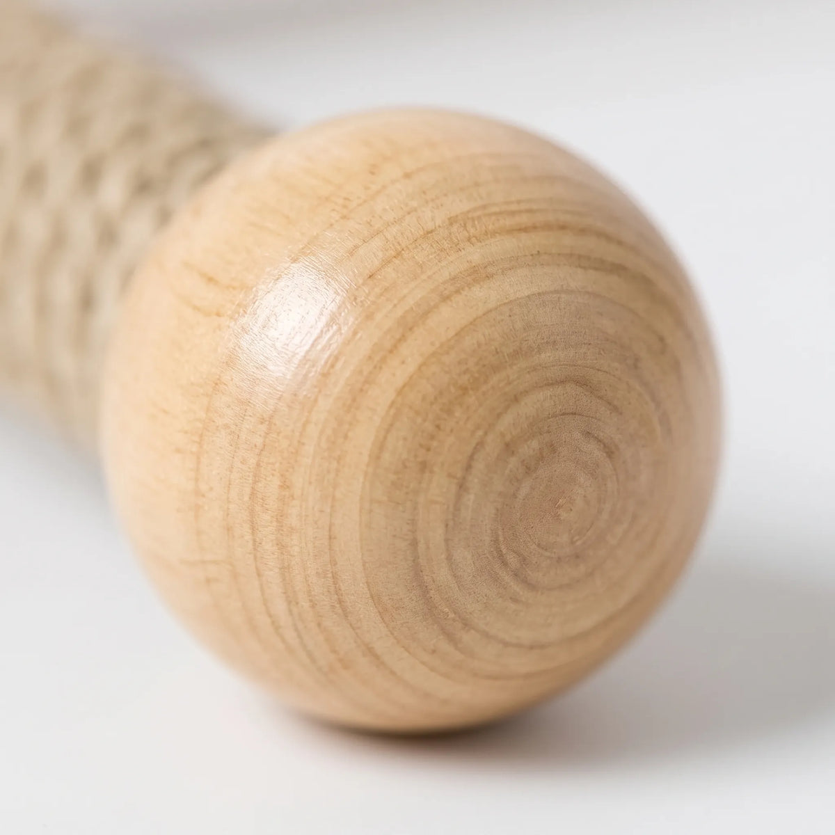 Close-up of a smooth wooden ball at the end of a perch arm, showing the fine grain rings and rope wrapping behind it. 3