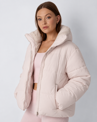 Three-quarter view of the pale pink puffer jacket worn open with hands in pockets, showing the fleece collar 7