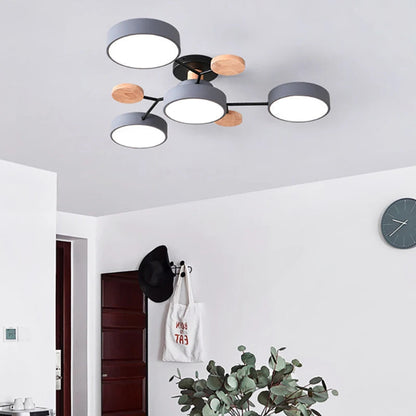 Grey four-shade ceiling light with black arms and wooden discs, hanging in a white hallway with a coat hook and wall clock. 5