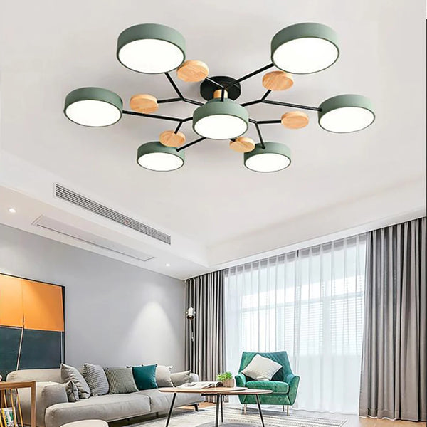 Green seven-shade ceiling light with black arms and wooden discs, fitted above a living room with a grey sofa and green armchair. 2