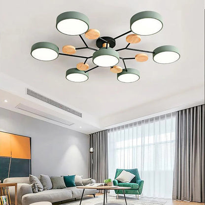 Green seven-shade ceiling light with black arms and wooden discs, fitted above a living room with a grey sofa and green armchair. 2