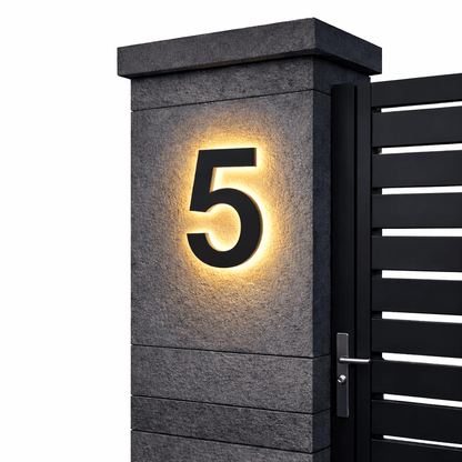Black number 5 with a warm backlit glow on a dark stone gatepost next to a black slatted gate. 8