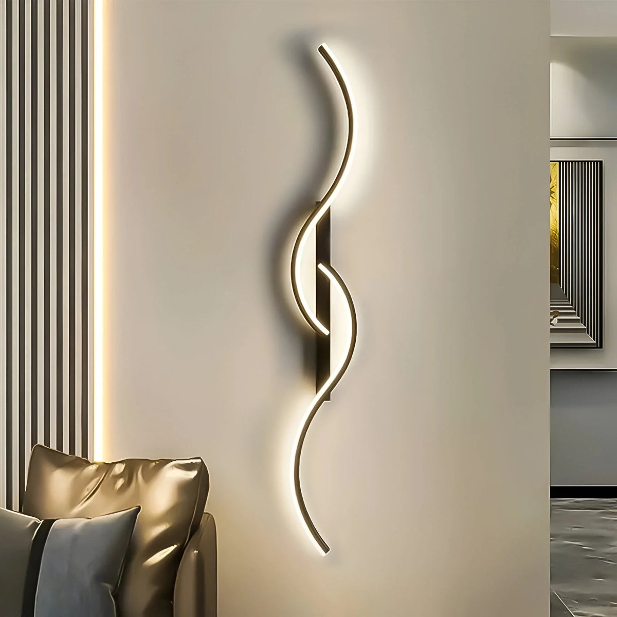 Black version of the curved wall light lit beside a cream wall and sofa 4