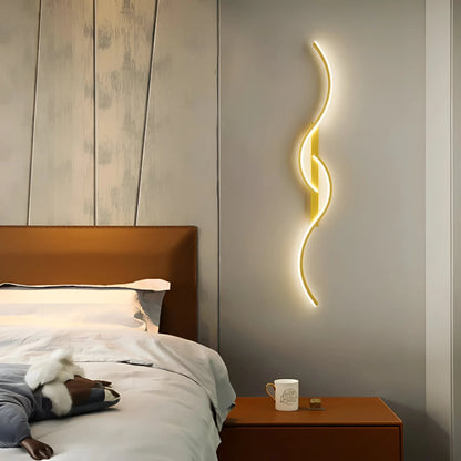 Gold curved wall light glowing above a bedside table in a bedroom 2