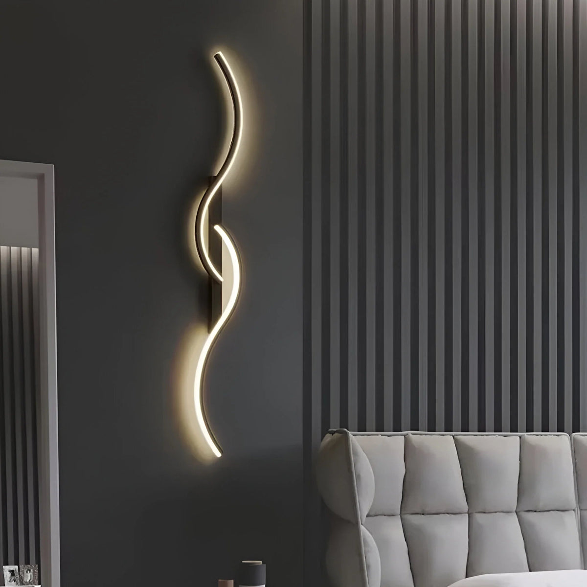 Black curved wall light lit on a dark grey wall above a grey sofa 6