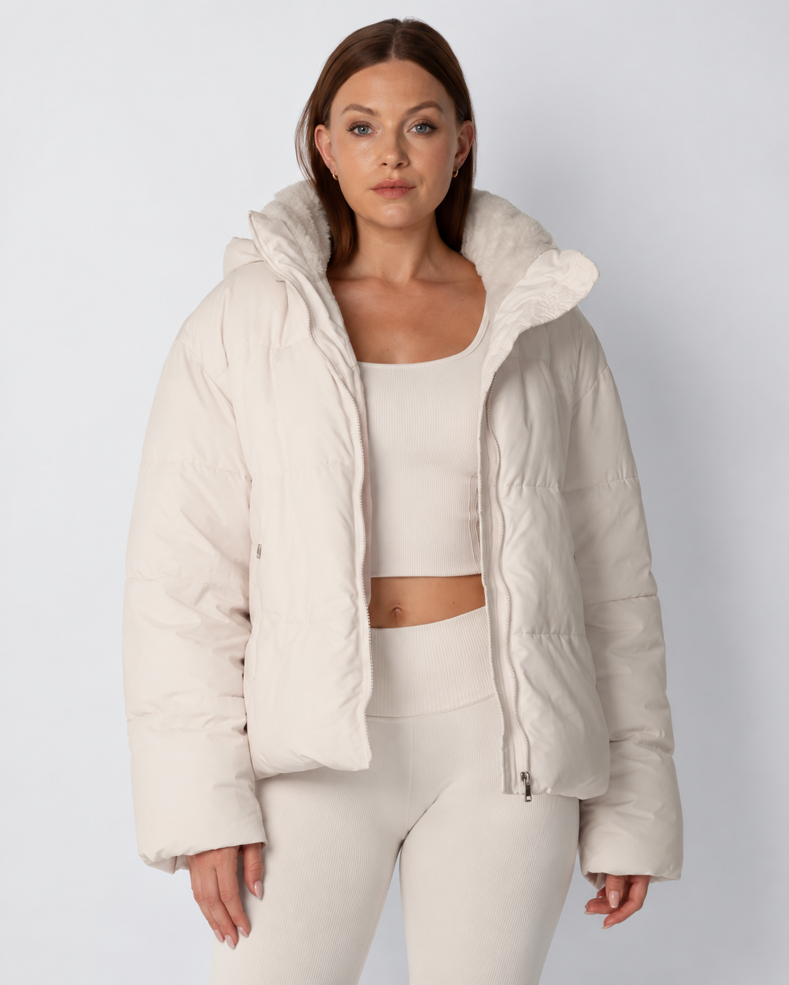 Model wears the cream puffer jacket open over a matching ribbed crop top and leggings, front view 1
