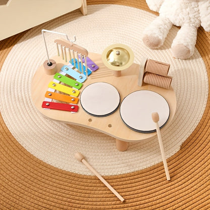 Overhead view of the music table on a round woven rug, with two mallets resting on the floor beside it. 8