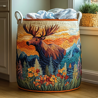 Quilted basket with an embroidered moose against an orange sunset, mountains and wildflowers, filled with towels and trimmed in orange. 6