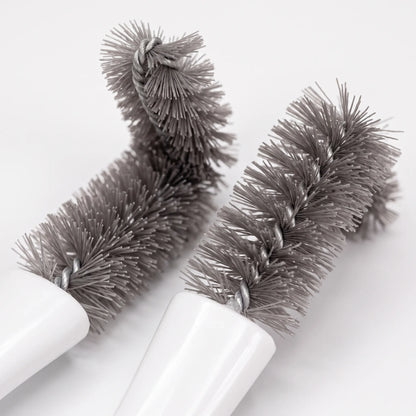 Close-up of two grey twisted-wire bristle heads, one bent at an angle, joined to white handles. 3
