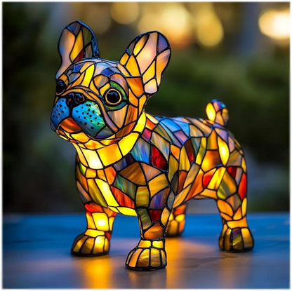 Standing French bulldog lamp with upright ears and blue muzzle, glowing amber and multicoloured on a blue surface outdoors. 7