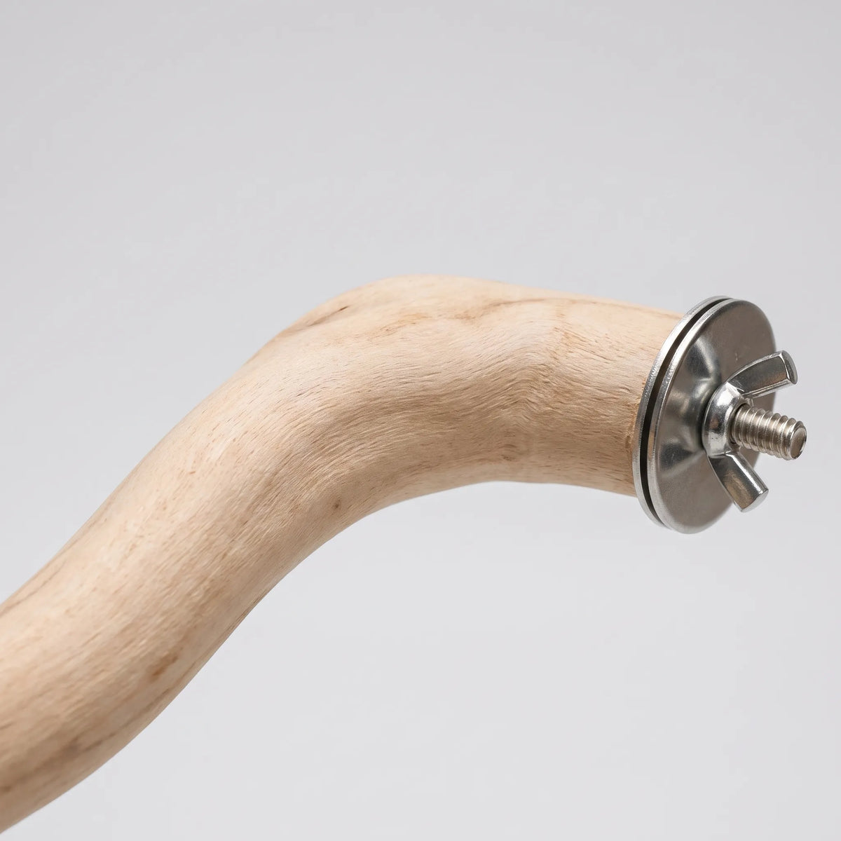 Close-up of the fixing end of the wooden perch, showing the metal washer, threaded bolt and wing nut against the wood grain. 3