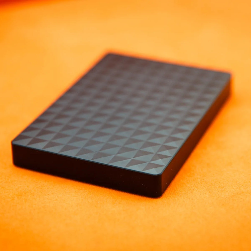 Close-up of the drive's raised pyramid pattern and slim edge against a bright orange background 4