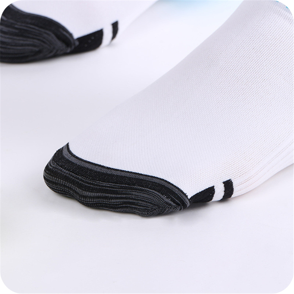 Close-up of the reinforced dark grey toe section of a white sock, with two black stripes behind the toe. 4