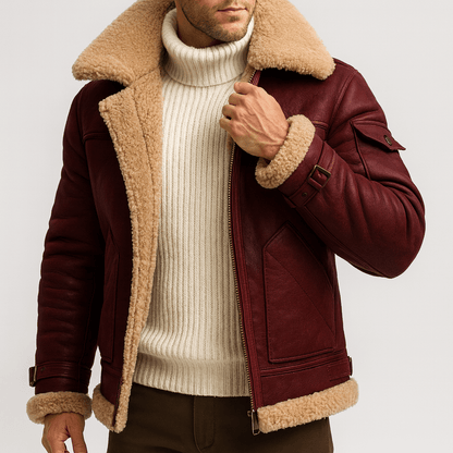 Close view of the burgundy leather jacket on a model, showing the shearling collar, buckled sleeve strap and large front pocket. 7