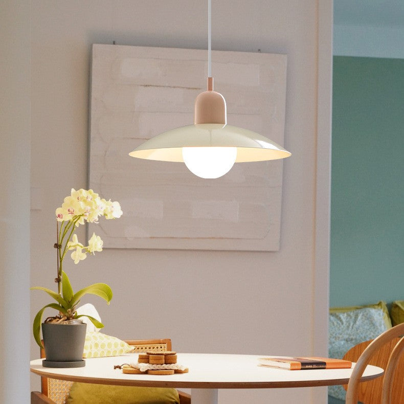 Cream pendant with pale pink cap hanging over a round dining table beside an orchid 2