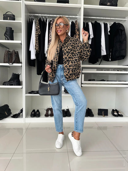 Full-length view of the leopard print bomber shacket styled with a black top, light blue jeans and white trainers in a dressing room. 5
