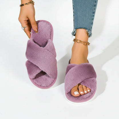 Mauve plush crossover slippers, one worn with ripped jeans and a gold anklet, the other held up showing the soft lining. 8