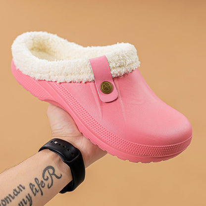 Hand holding a pink clog with cream faux fur lining against a tan background 16