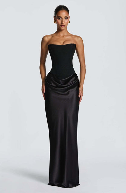 Front view of the black strapless corset dress worn by a model, with draped satin skirt 21