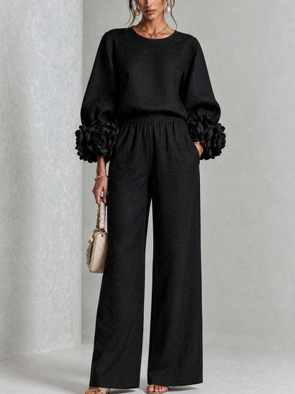 Black version of the set worn by a model, front view, with oversized flower cuffs 2