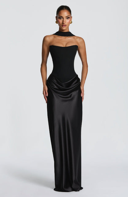 Front view of the black dress with the choker band at the neck, model standing straight 24