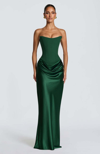 Model facing forward in a strapless emerald green corset maxi dress with draped satin hip 1