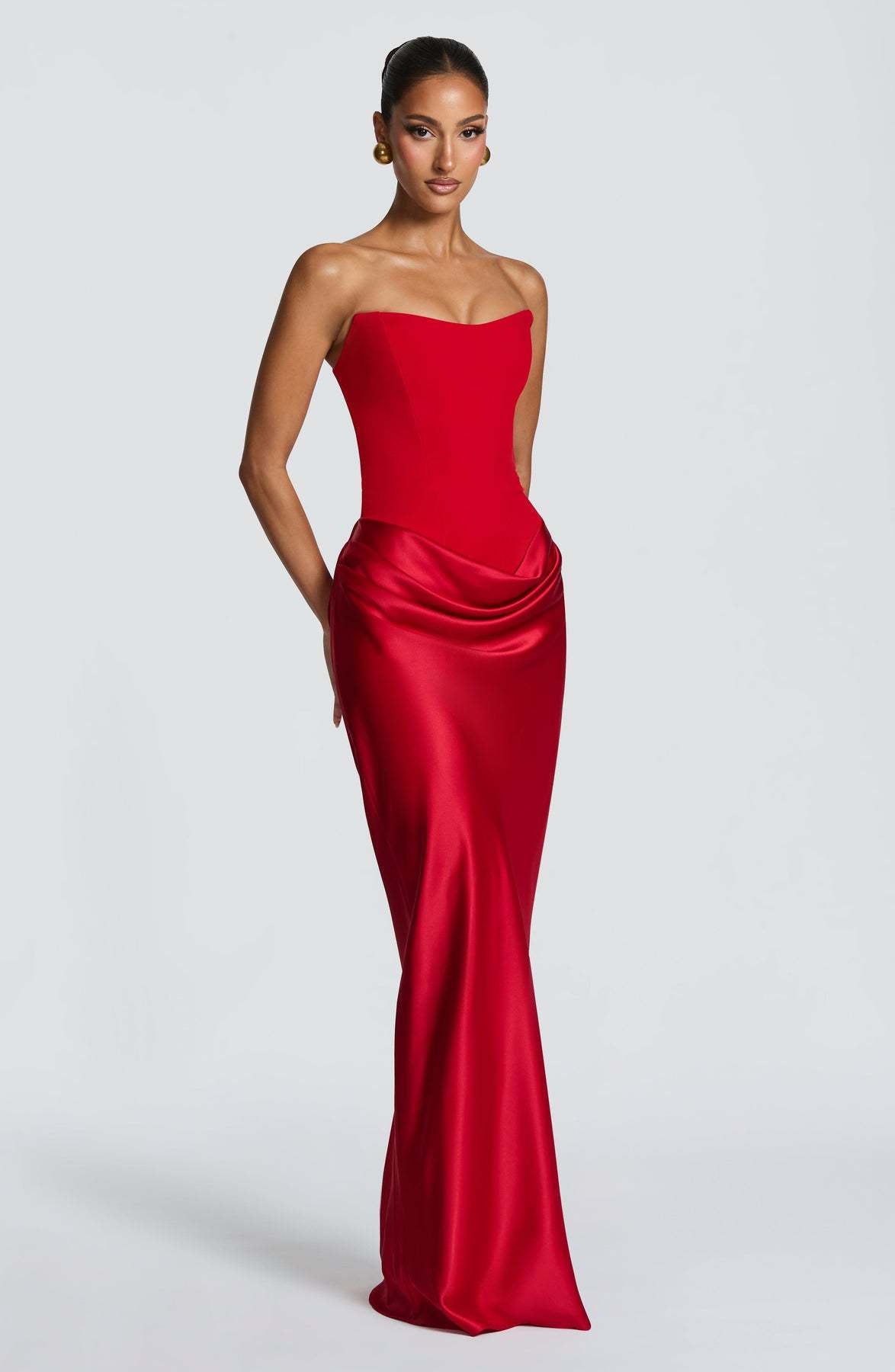 Angled front view of the red strapless dress showing the satin hip drape and flared hem 30