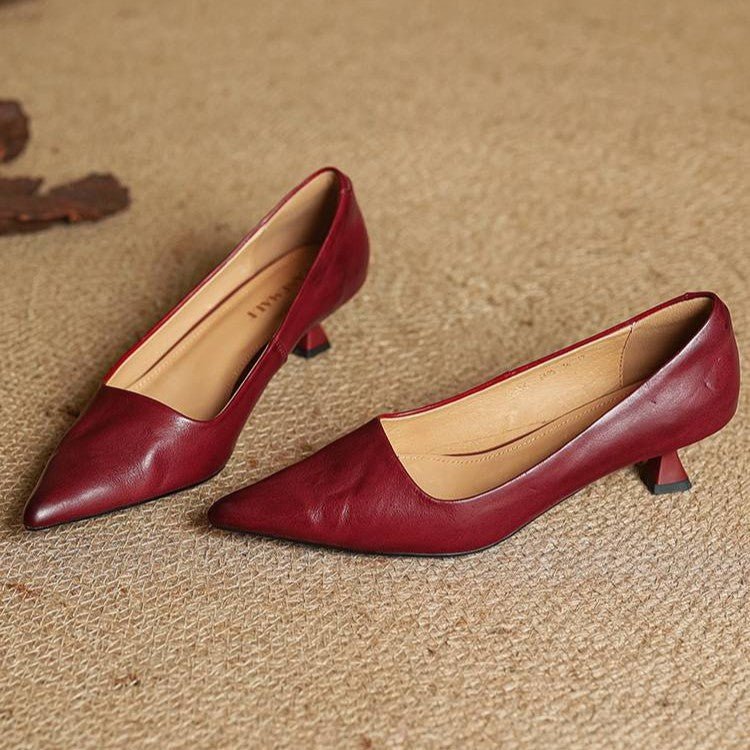 Pair of red leather pumps on woven matting showing the tan leather lining 11