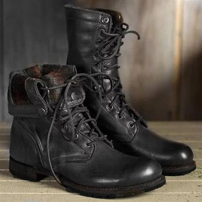Pair of black leather lace-up boots, one with its cuff folded down to show a patterned fabric lining. 2