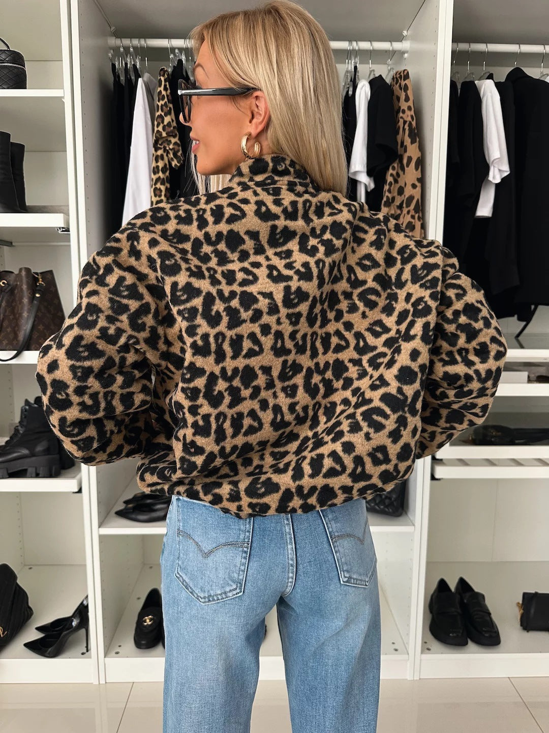 Back view of the leopard print bomber shacket on a woman in jeans, showing the standing collar and full-cut sleeves. 2
