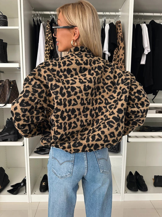 Back view of the leopard print bomber shacket on a woman in jeans, showing the standing collar and full-cut sleeves. 2
