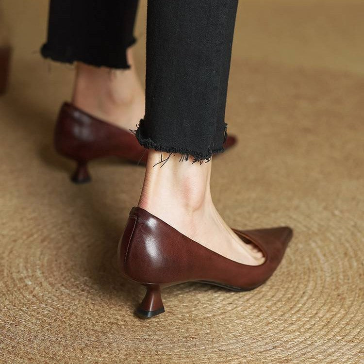 Back view of brown leather kitten heels showing the curved flared heel on a model 20