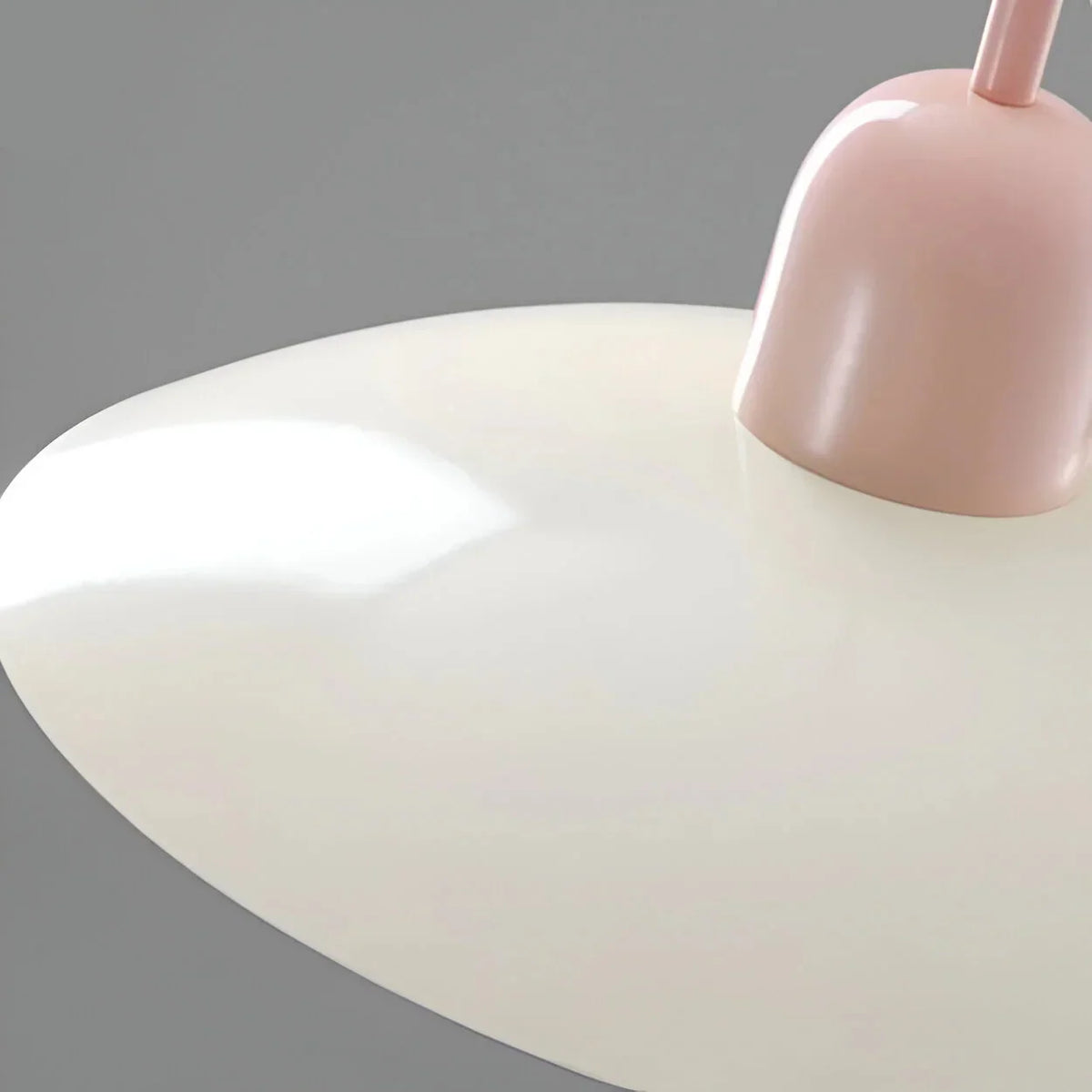 Close-up of the glossy cream shade and rounded pink cap against a grey background 12