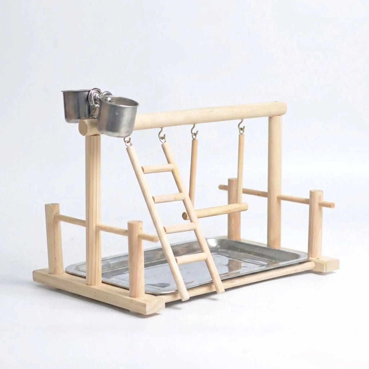 Natural wooden bird playground with ladder, swing, two steel feeding cups and a steel tray, shown empty on a plain background. 1