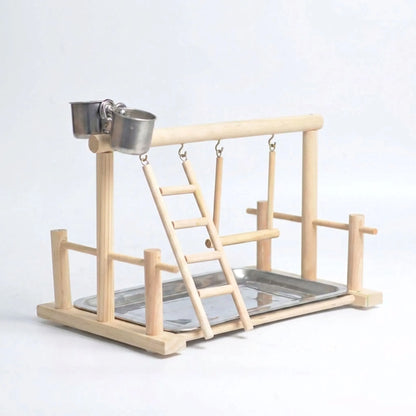 Natural wooden bird playground with ladder, swing, two steel feeding cups and a steel tray, shown empty on a plain background. 1