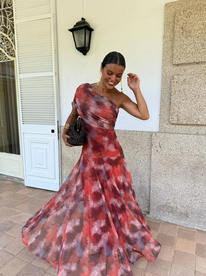 Model twirling in the red, pink and purple abstract-print mesh dress, one shoulder bare 2