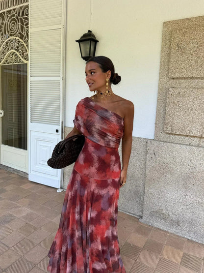 Model in the abstract red-toned print one-shoulder dress, with draped bodice and flared skirt 11
