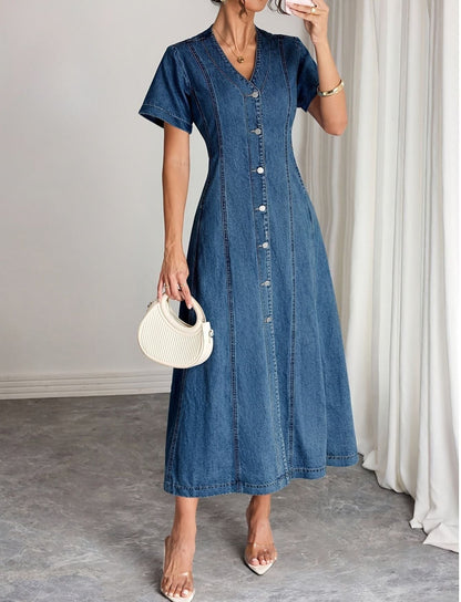 Model in the button-front midi dress holding a cream ribbed handbag, one hand raised near her face 1